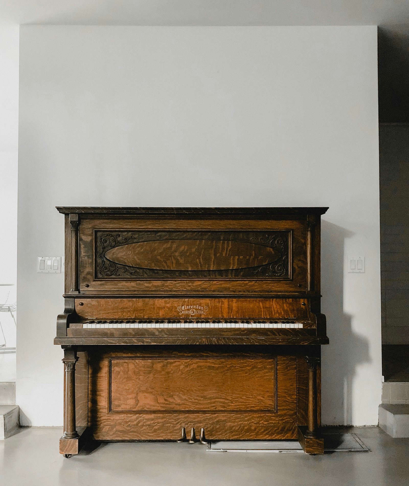 Movers wrapping an upright piano with blankets and straps